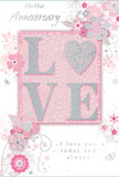 This anniversary card radiates a tender, intimate mood, its design steeped in soft pastel pinks and misty silvery greys, reminiscent of a peaceful evening sky over Harmondsworth. In the centre, the word LOVE stands proudly in gently raised glitter, the letters smooth and tactile to the fingertips. The O is transformed into a shimmering silver heart, textured to catch the light like a polished charm. Around this focal word, clusters of delicate blooms unfold in shades of blush and muted mauve, their petals painted with a watercolor softness that fades gently at the edges. The flowers appear hand-drawn and carefully placed, curving outward in fluid arcs like the natural sweep of stems in a romantic bouquet. Fine swirls, tiny petals, and a scattering of subtle, almost transparent butterflies weave through the composition, suggesting motion and the quiet joy of an English spring garden just beyond a Harmondsworth doorway. Silver accents highlight some of the leaf tips and petal edges, adding a refined shimmer similar to luxury gift wrap for anniversary flowers. At the top and lower section of the card, the phrases On Our Anniversary and I love you today and always are written in an elegant script, the letters slim and flowing, as if handwritten with care. The overall design feels gentle and deeply personal, a keepsake that complements anniversary flower deliveries across Harmondsworth-from cottages near the historic barns to homes tucked beside tree-lined lanes-marking a shared journey with subtle beauty and heartfelt warmth.